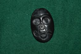 A carved mask pendant.