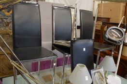 A set of four chrome and black leather dining chairs.
