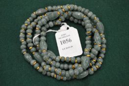 A green hard stone bead necklace.