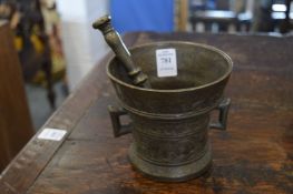 A cast metal pestle and mortar.