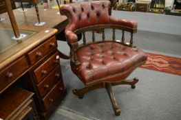 A button upholstered red leather office swivel armchair.