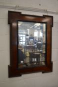 A wall mirror with a shaped oak frame.