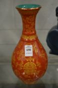 A Chinese bottle vase, red glazed with gilt decoration.