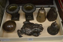 A pair of small cast bronze pedestal urns, a bronze frog, small bells etc.