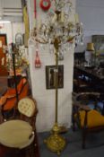 Highly ornate brass floor standing lamp with eight scrolling branches hung with cut glass pear