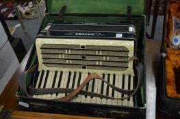 A cased Hohner Carmen II piano accordion.