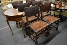 A set of six oak framed dining chairs with brass close-nailed leather upholstery.