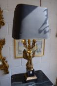 A large brass Empire style eagle lamp base with shade.