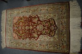A good Persian silk carpet with floral decoration, 128cm x 82cm.