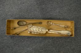 A pair of white metal asparagus tongs and other items.