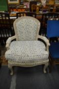 A French style open armchair with painted frame and floral upholstery.