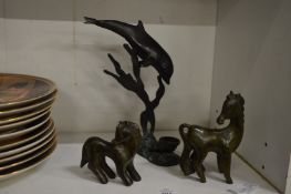 A small bronze dolphin and two bronze horses.