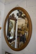 A gilt framed oval mirror.