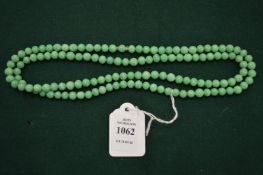 A mottled jade bead necklace.
