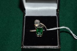 An 18ct white gold emerald and baguette cut diamond crossover ring.