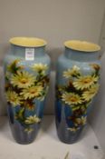 A pair of floral decorated pottery vases (one with rim chips and cracks).