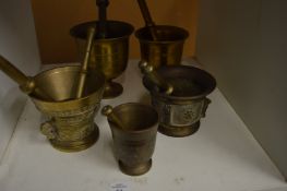 A group of brass pestle and mortars.