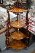 A VICTORIAN FIGURED WALNUT GRADUATED FOUR TIER CORNER WHATNOT, with pierced side supports. 128cms