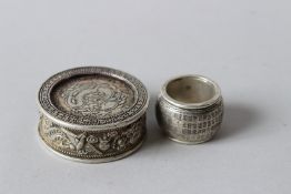 A CHINESE WHITE METAL RING AND A CHINESE COIN BOX. Ring 3cms. Box 5cms.