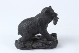 A SMALL BRONZE FIGURE OF A BEAR WITH A FISH IN ITS MOUTH. 15cms long.