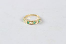 AN 18CT GOLD, EMERALD AND DIAMOND ETERNITY RING.