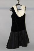 A BLACK VELVET AND SATIN DRESS, with broad white collar.