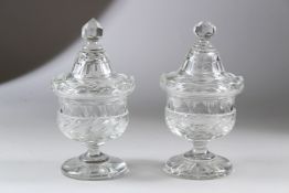 A PAIR OF CUT GLASS PEDESTAL COMPORTS AND COVERS. 19cms high.