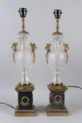 A PAIR OF CUT GLASS AND ORMOLU URN SHAPED TABLE LAMPS, with marble bases. 63cms high.