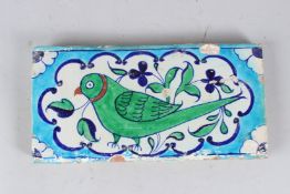 A FINE 18TH-19TH CENTURY NORTH INDIAN MULTAN GLAZED POTTERY TILE depicting a parrot. 31cms long.
