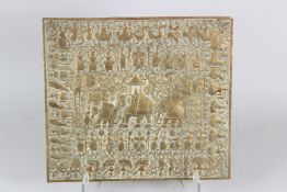 A 19TH CENTURY SRI LANKAN ENGRAVED AND EMBOSSED BRASS PANEL depicting ceremonial scenes. 32cms x