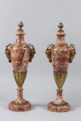 A PAIR OF RED VEINED MARBLE AND ORMOLU URNS with satyr monk handles. 43cms high.