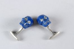 A PAIR OF SILVER AND BLUE ENAMEL SKULL CUFFLINKS.