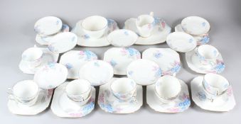 A SHELLEY TWELVE PLACE TEA SERVICE decorated with blue and pink flowers.