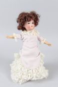 A SMALL VICTORIAN BISQUE PORCELAIN HEADED DOLL. 28cms high.