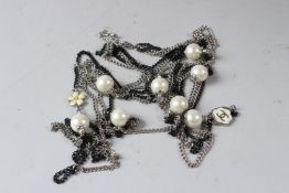 A CHANEL LONG NECKLACE, with black and silver coloured chains interspersed with pearls.