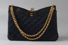 A CHANEL LADIES NAVY BLUE QUILTED HANDBAG, with black leather trim and dust bag.