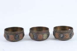 THREE 19TH CENTURY INDIAN TANJORE SILVER AND COPPER INLAID BRASS BOWLS with figural decoration.