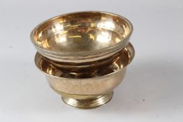 TWO 19TH CENTURY INDIAN BRASS BOWLS, one foot detached, the other with an old repair.