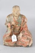 A CARVED WOOD AND POLYCHROME STATUE OF A SEATED MONK OF ARHAT. 30cms high.