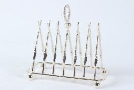 A PLATED TOAST RACK OF CROSSED RIFLES DESIGN. 19.5cms wide.