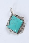 A SILVER AND TURQUOISE PENDANT.