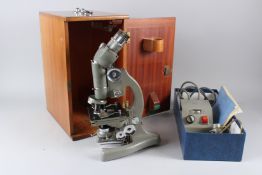 A BECK MODEL 3228 BINOCULAR MICROSCOPE, with electronic attachment, cased.