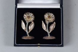 A PAIR OF CAST SILVER FLOWERS, possibly place name holders, in a fitted case. 6.5cms high.