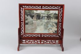 A CHINESE HARDWOOD TABLE SCREEN with pierced decoration, the revolving double sided panel