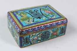 A 20TH CENTURY JAPANESE CLOISONNE BOX, with hinged cover, decorated with flowers and calligraphy.