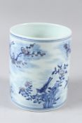 A CHINESE BLUE AND WHITE BRUSH POT, painted with birds amongst prunus trees. 15cms high.