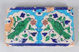 A FINE 18TH-19TH CENTURY NORTH INDIAN MULTAN GLAZED POTTERY TILE depicting two birds. 30cms long.
