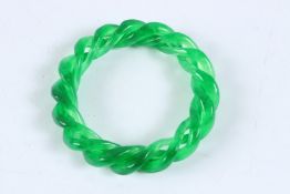 A GREEN JADE TWIST BANGLE. 9cms.