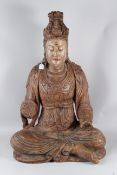 A LARGE CARVED WOOD FIGURE OF GUANYIN sitting cross legged, hands missing. 94cms high x 58cms wide.