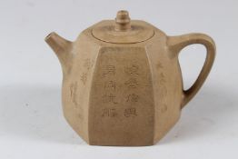 A CHINESE YIXING POTTERY TEAPOT, of hexagonal form, incised with calligraphy. 15cms wide.